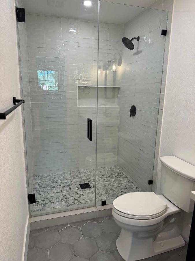 Walk-in shower with clear glass and white tile