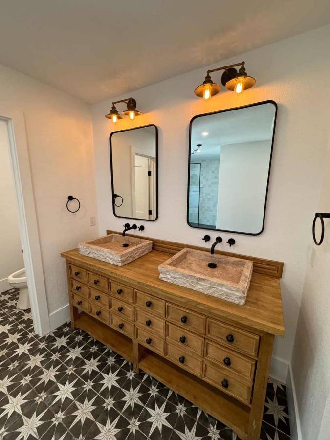 Bathroom with wood double vanity and stone vessel sinks