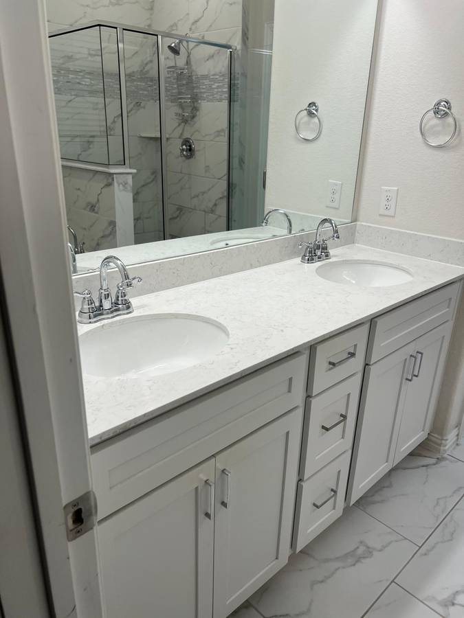 White double vanity with quartz counter and marble tile floor